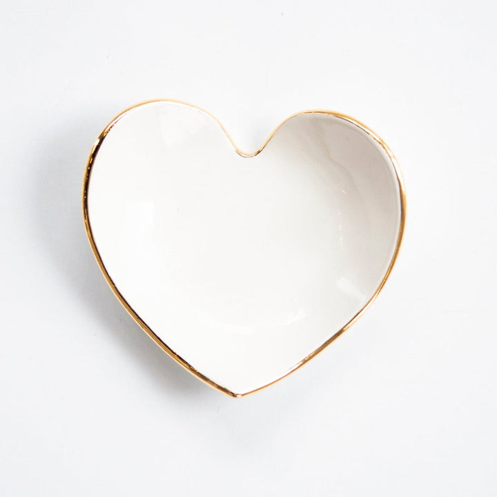 White heart ring dish with a gold rim, angled product view on white