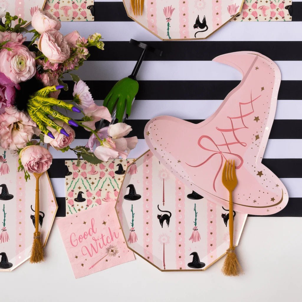 Pink witch-themed party supplies for a Wicked-inspired Halloween party.