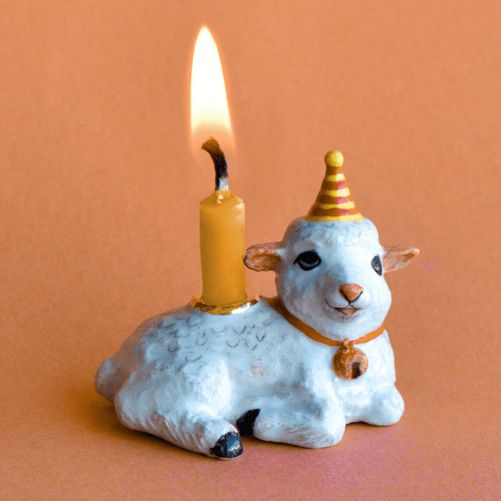 Lamb cake topper candle holder in a striped party hat, a Year of the Goat Chinese zodiac birthday cake topper